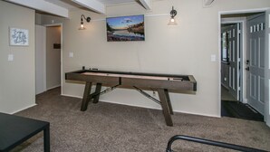 A pool table in a room with beige walls, a painting above it, and two wall-mounted lights. - Escape to Bearadise - Close to Slopes, Shuffleboard, Fireplace, BBQ (Big Bear Lake)