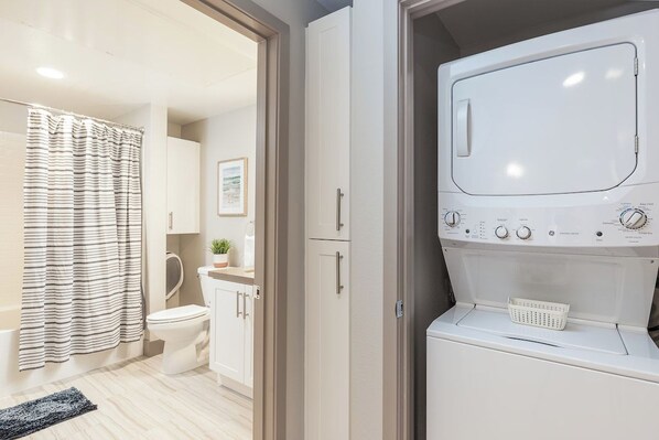Modern bath with in-unit washer/dryer for added guest convenience