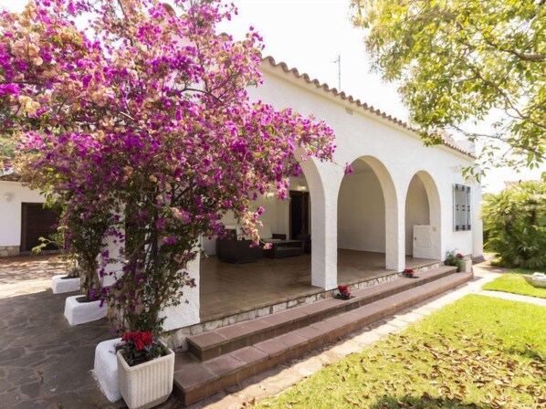 A white building with arches and a covered porch.