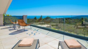 A balcony with a clear view of the sea, a chair, and towels. - Vacation home A.R.T. by Interhome (Labin)