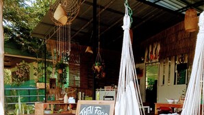 Un espacio al aire libre acogedor con hamacas, un cartel de pizarra que dice