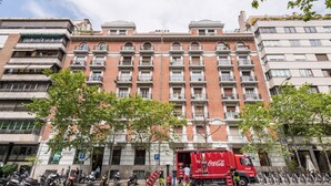 A multi-story building with balconies, a Coca-Cola delivery truck, and parked scooters. - Genteel Home Velazquez II (Madrid)