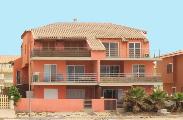 A multi-story building with balconies, a flat roof, and a satellite dish. - Apartment 100 meters the Atlantic Ocean with large terrace in front (Santa Maria)