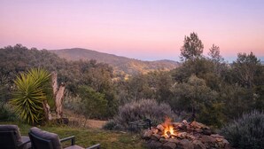 A fire pit with a view of a forested hillside. - Hilltop Hideaway, Firepit, Starry Nights & Privacy (Mullamuddy)