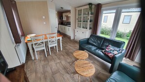 Un espacio habitable compacto con comedor, sofá y una pequeña mesa.
