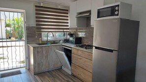 Microondas, cafetera y tetera, utensilios de cocina y comedor 