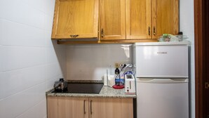 A small kitchen with wooden cabinets, a white refrigerator, a toaster, and a kettle. - Everything ready to enjoy the summer, swimming pools, near the sea, tennis and more... (Torrevieja)
