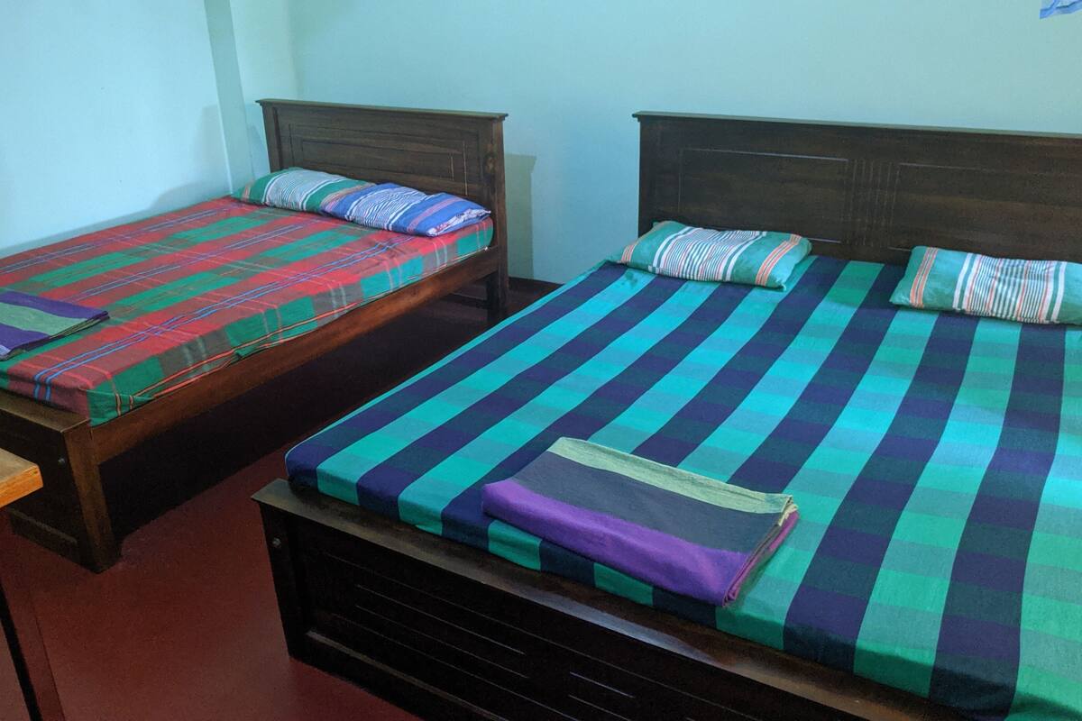 Two single beds with wooden headboards and colorful striped bedding.
