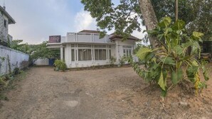 A two-story building with a white exterior and a sign indicating a business on the ground floor.