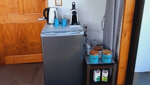 Una habitación compacta con kitchenette, televisión montada en la pared y puerta corrediza.