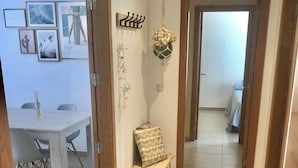 Ein Flur mit einer Holzbank, einer blumengeschmückten Dekoration und einem an der Wand befestigten Kleiderhaken.