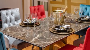 A dining table set with plates, glasses, and a champagne bottle. - SPANISH STEPS Extra Luxury Apartment (Roma)