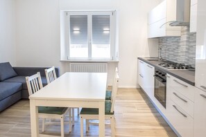 Een koelkast, een oven, een vaatwasser, eettafels