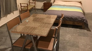 A small, cozy room with a single bed, a wooden table with chairs, and a window with curtains. - Taygetos (Sparta)