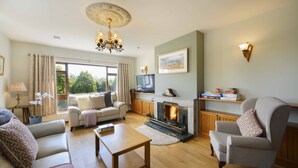 A living room with a fireplace, sofas, a coffee table, and a television.
