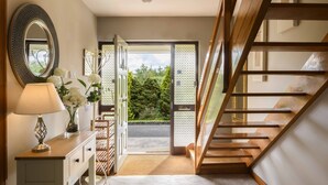 A staircase leading to a balcony with a view of greenery.