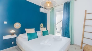 Un dormitorio con una cama grande, una lámpara de noche, aire acondicionado instalado en la pared y vistas al exterior.