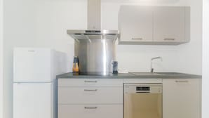 Cocina moderna con extractor de acero inoxidable, lavavajillas y horno empotrado.