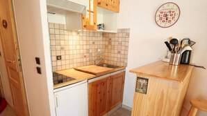 A compact kitchen with a wooden countertop, a sink, and a small wooden cabinet. - Cozy Mountain Apartment - Sleeps 6, 2 Balconies, Near Slopes - Arêches-Beaufort (Arêches-Beaufort)