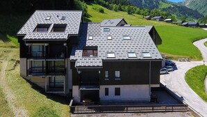 A modern two-story house with a sloped roof, large windows, and a balcony. - Cozy Mountain Apartment - Sleeps 6, 2 Balconies, Near Slopes - Arêches-Beaufort (Arêches-Beaufort)