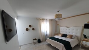A bedroom with a large bed, a TV mounted on the wall, a small side table, and a nightstand. - Beautiful holiday home in Paris (Paray-Vieille-Poste)
