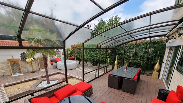 A covered outdoor patio with seating areas, a small pool, and a view of the surrounding garden. - Beautiful holiday home in Paris (Paray-Vieille-Poste)