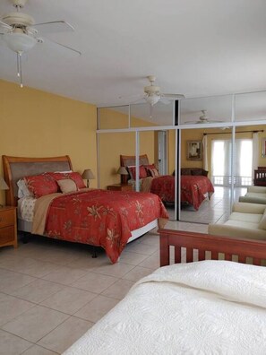 A hotel room with a large bed, a smaller bed, a sofa, and a ceiling fan. - Romantic Beachfront Paradise Villa with Incredible Ocean Views & Outdoor Event Space (Islote Arecibo)