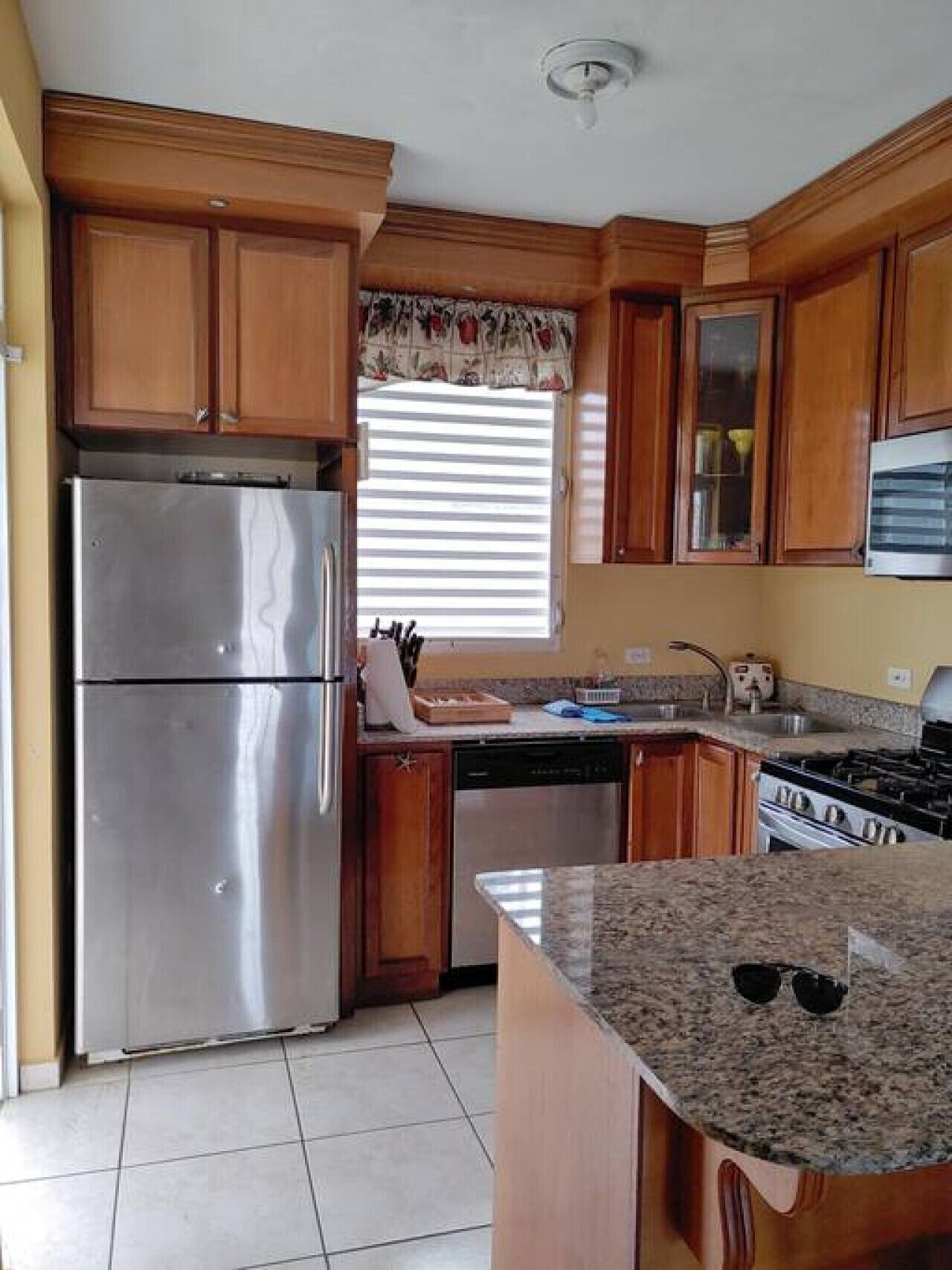 A kitchen with wooden cabinets, stainless steel appliances, and a granite countertop.