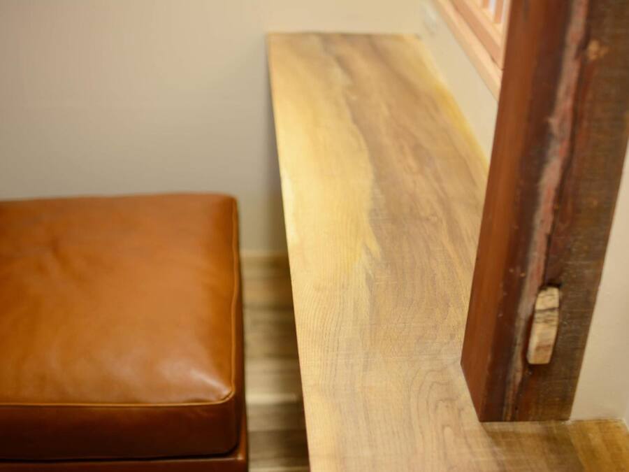 A wooden bench with a leather seat and a wooden table.