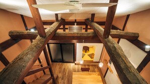 A wooden staircase with a ceiling fan, a wooden table, and a door leading to another room. - MINKA Riverside Villas (Imizu)
