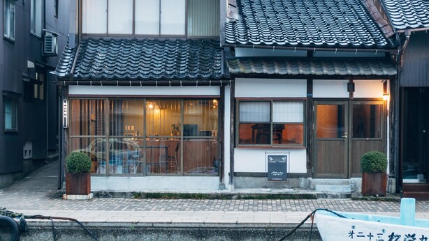 A traditional Japanese building with a tiled roof, large windows, and a small garden area with potted plants. - MINKA Riverside Villas (Imizu)