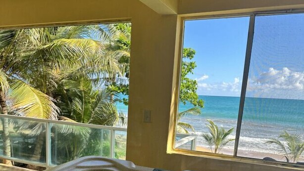 A hot tub with a clear view of the beach and palm trees. - Luquillo Beachfront Villa with Ocean Views & Room to Relax (Luquillo)