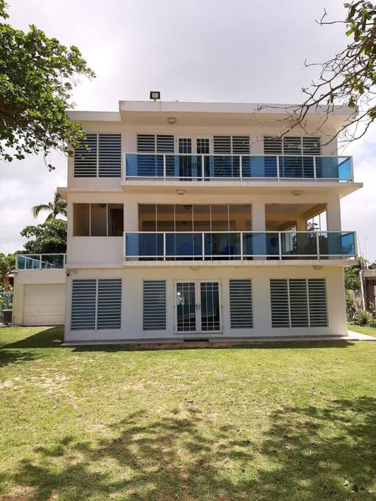 A three-story building with balconies and large windows.