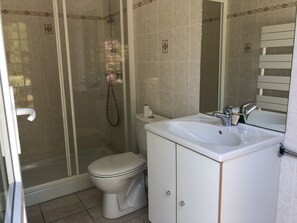 Une salle de bain équipée de toilettes, d ’une douche, d’un lavabo et d’un miroir.