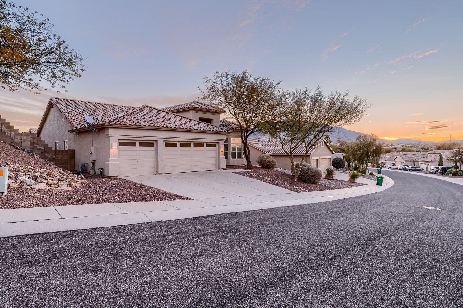 A residential house with a tiled roof, a garage, and a driveway.