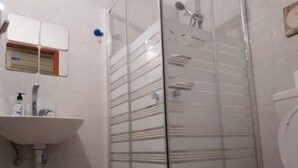 A bathroom with a glass shower enclosure, a sink, and a toilet. - Cozy 2 Bedroom Apartment by The Beach (Tel Aviv)
