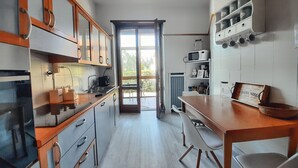 Eine moderne Küche mit Holzausstattung, einem eingebauten Backofen und einem Essbereich mit Tisch und Stühlen.