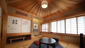 Een traditionele Japanse kamer met tatami vloerbedekking, een lage tafel en schuifdeuren met kalligrafie.
