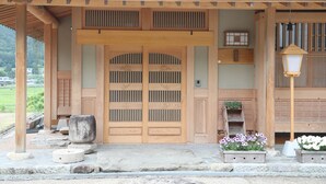 Een traditioneel Japans gebouw met een houten ingang, stenen trappen en bloembakken.