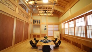 Een traditionele Japanse kamer met houten inrichting, een tafel van tatami-matten en een shoji-scherm raam.