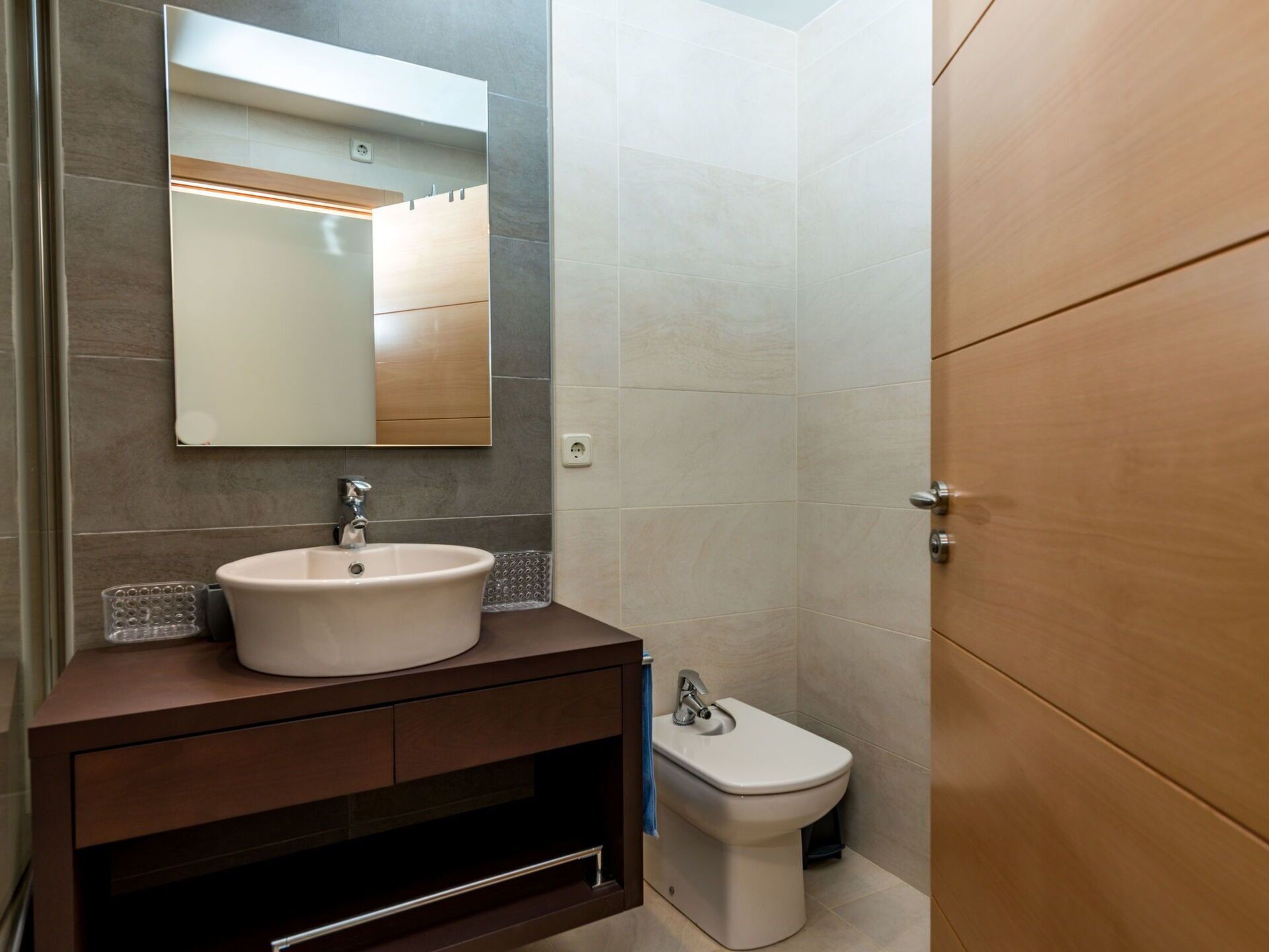 A bathroom with a sink, mirror, and toilet.
