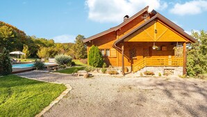 A log cabin with a stone patio, a swimming pool, and a well-maintained garden. - Lovely home in Gospic (Gospic)