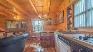 A cozy cabin interior with a wooden interior, a dining area, and a kitchen with modern appliances. - Lovely home in Gospic (Gospic)
