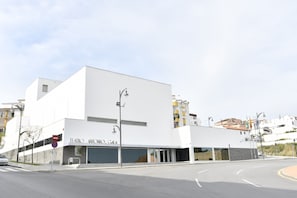 Un edificio moderno con fachada plana, ventanas amplias y un cartel que dice "TEATRO ANTONIO GIA".