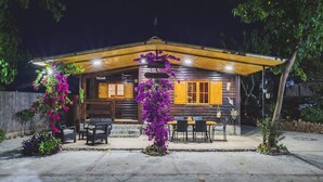 Une cabane en bois dotée d’un patio couvert, de meubles d’extérieur et d’une enseigne sur laquelle on peut lire « Paix ».