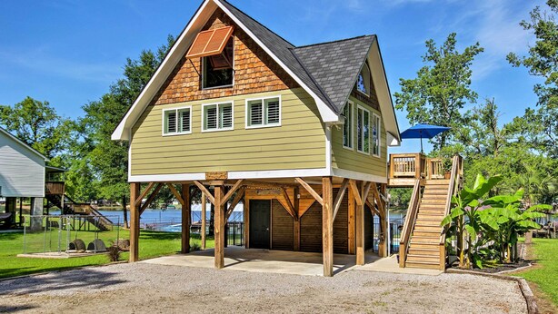 A two-story house with a covered porch, a wooden staircase, and a view of a lake. - Camden Home on Lake Wateree w/ Boat Dock! (Camden)