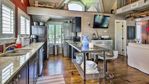 A spacious kitchen with a large island, stainless steel appliances, and a TV mounted on the wall. - Camden Home on Lake Wateree w/ Boat Dock! (Camden)