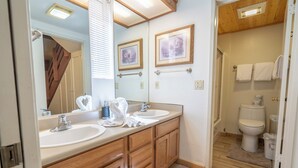 A bathroom with wooden cabinets, two sinks, a large mirror, and a toilet. - Edgewater #10 , Magnificent Panoramic view of June Lake through lg picture window (June Lake)