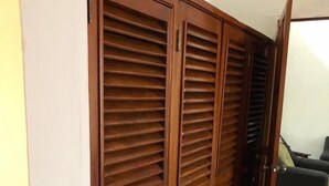A wooden wardrobe with multiple compartments and a sliding door. - Casa Bahía Department 1 (Centro)