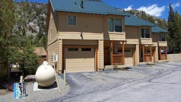 A two-story building with a garage, a porch, and a large decorative sculpture. - Hideaway #103, views of Carson Peak (June Lake)